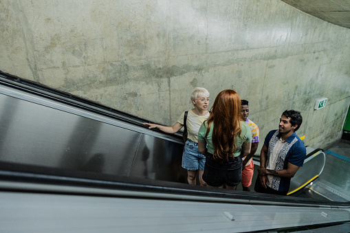 Friends talking on the escalator in a subway station