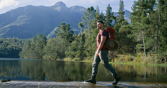 Mountains, thinking and hiking with a lake, man and environment with adventure, water and journey. Forest, person and hiker with breathing, healthy and landscape with wellness, outdoor and peace