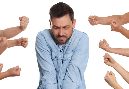 People bullying scared man on white background