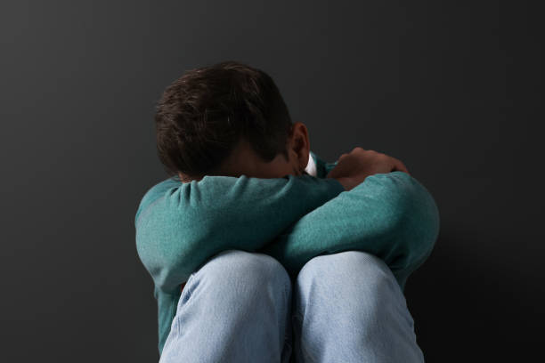 istock Upset mature man sitting near black wall 1806470284