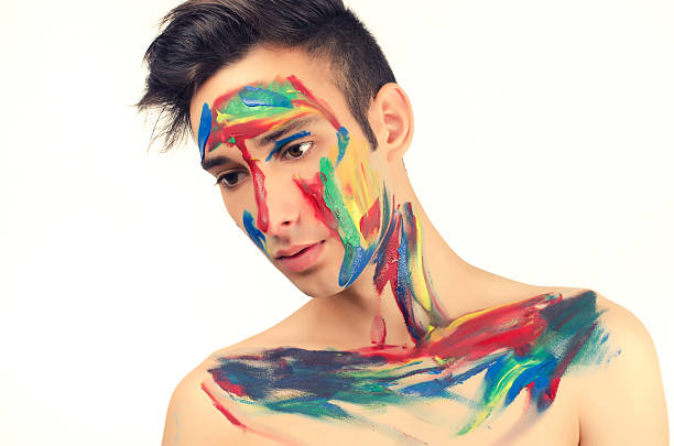 istock Beautiful young man painted on the face with many colours 180648911