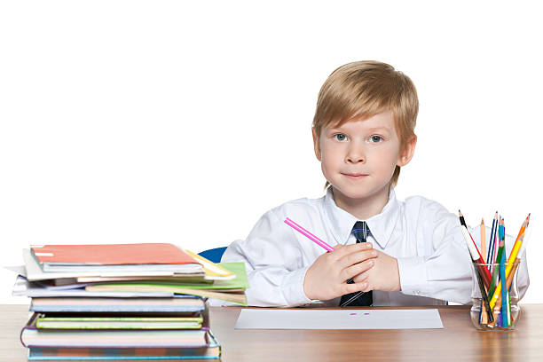 istock Red-haired young boy is sitting at the desk 180650134
