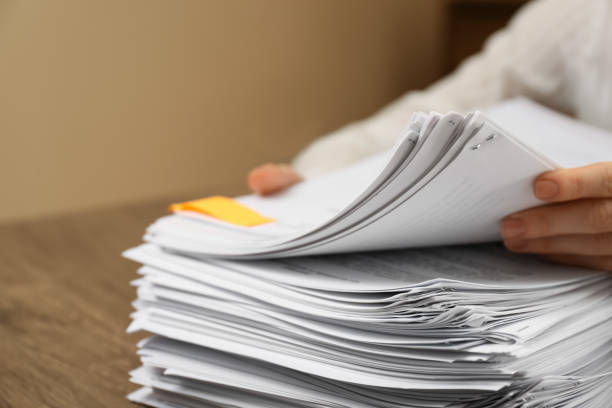 istock Woman stacking documents at wooden table indoors, closeup 1806513057