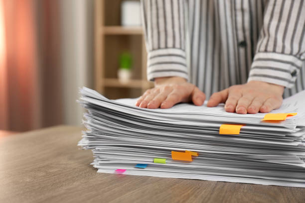 istock Woman stacking documents at wooden table indoors, closeup 1806513088