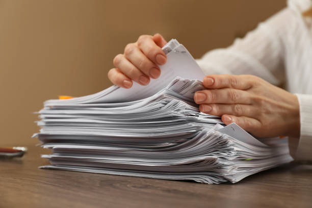 istock Woman stacking documents at wooden table indoors, closeup 1806513103