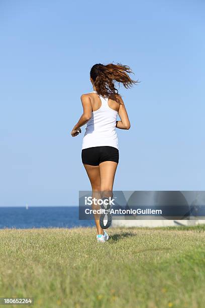 Vista Posterior De Joven Mujer Corriendo Foto de stock y más banco de imágenes de Actividad - Actividad, Adolescente, Adulto