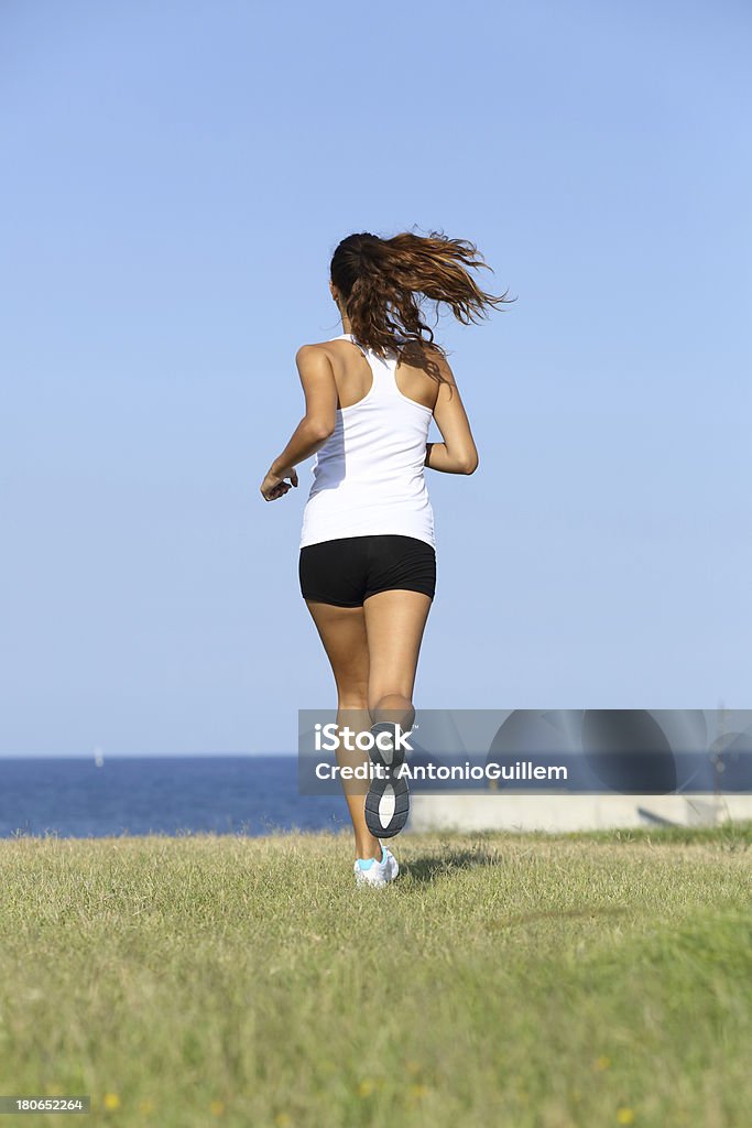 Vue arrière d'un jeune femme en train de courir - Photo de Activité libre de droits