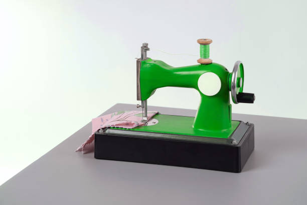 istock Children's small chain stitch sewing machine with manual drive is on the desktop 1806524123