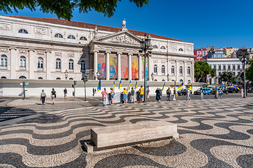 Lisbon, Portugal - Sep 30, 2023: People protest in the square with slogans NATO STOP RUSSIA'S GENOCIDE IN UKRAINE. View of the famous landmark -  Rossio square and Teatro Nacional Dona Maria II,  Lisbon, Portugal.