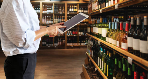 istock Liquor store manager inventories product using digital tablet. 1806545489