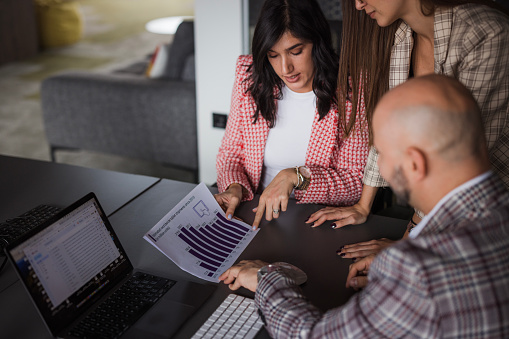 Business woman analyzing business via charts and diagrams with her colleagues