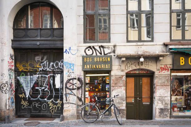велосипед возле магазина с граффити в копенгагене, дания - danish culture denmark old fashioned sign стоковые фото и изображения