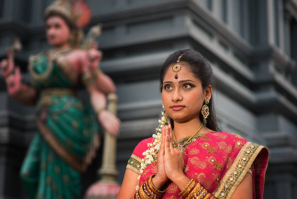 junge indische frau beten - bollywood prayer position indian culture indian ethnicity stock-fotos und bilder