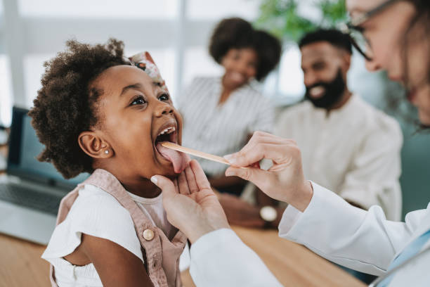istock Pediatrician analyzing throat infection with tongue stick 1806604823
