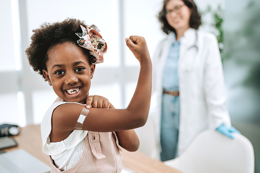 Child with bandage on arm after vaccine