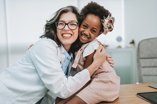 Doctor hugs child patient