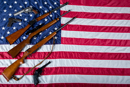 US Second Amendment Constitutional Right to Bear Arms with firearms resting on American Flag.