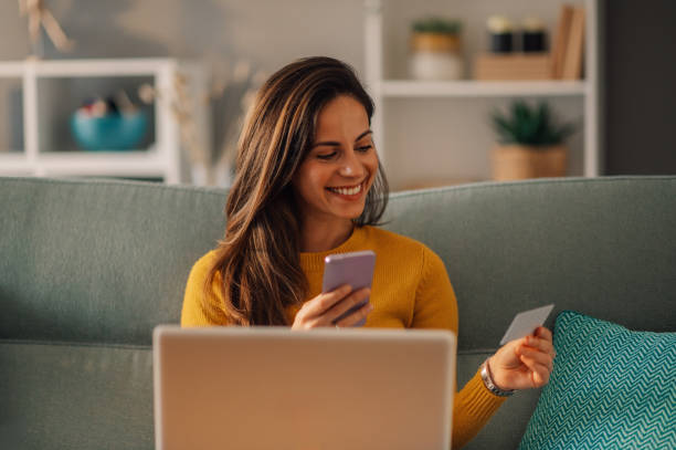 istock A happy woman is sitting at home and using technologies for online shopping. 1806649143