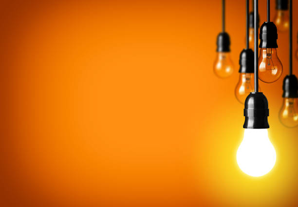 istock Light bulbs hanging against a yellow background 180665729