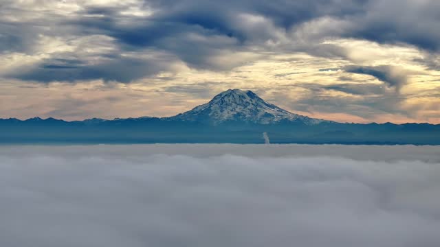 Dramatic Sunset View Of Mount Rainier With Overcast In Washington, USA. Sea Of Clouds In Foreground. wide shot