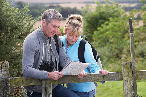 pareja madura en campo pie - map uk hiking reading fotografías e imágenes de stock