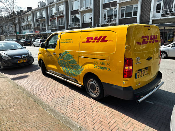 dhl delivery van on street netherlands - driving delivery van global business dhl imagens e fotografias de stock