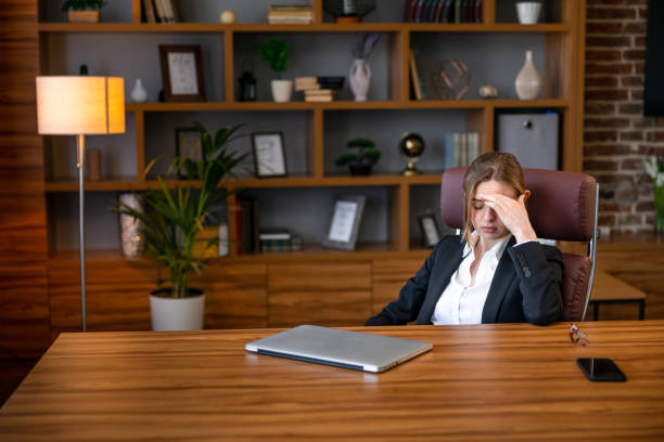 istock Stressed and tired young woman with headache at workplace 1806714720