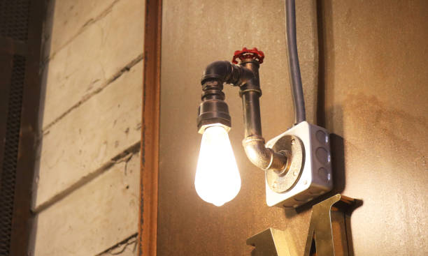 istock Industrial edison light bulb install hanging on factory wall. 1806787107