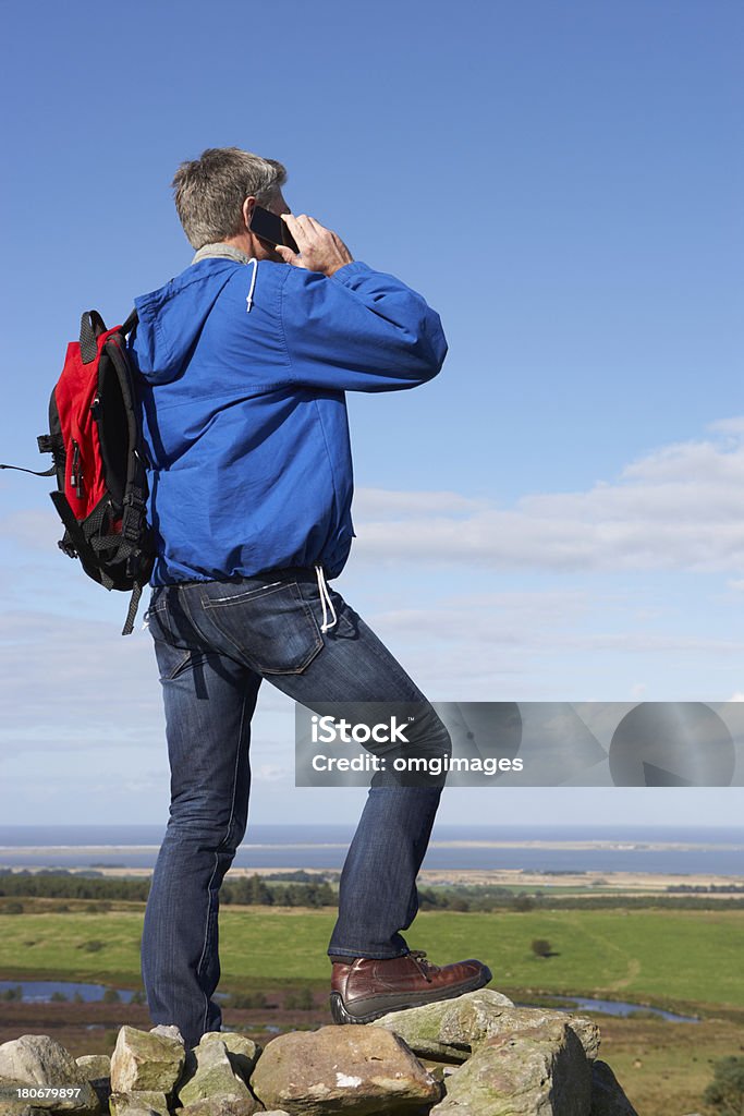 Hombre mediante teléfono móvil en la campiña remoto - Foto de stock de Escena rural libre de derechos