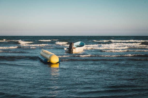 istock Boat with an inflatable float on the sea waves 1806806611