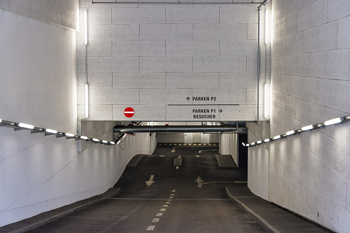 picture of the entrance or exit to a parking garage, the writing on the wall means Parking P2 and Parking P1 visitors in English
