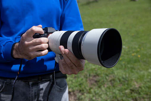 professional photographer with camera in hands outdoors
