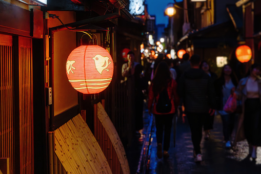 alley in the Ponto-cho district in the Kyoto old town at night, with focus on a Japanese lantern in the foreground