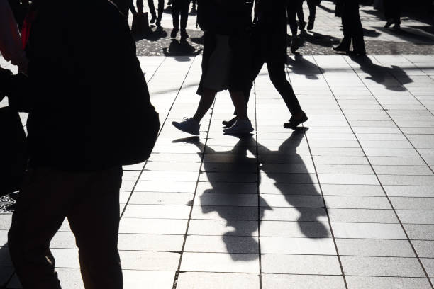 istock Backlit silhouettes of pedestrians walking in a pedestrian zone 1806830897