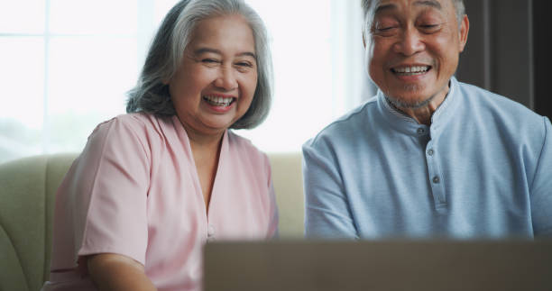 istock Relaxed mature old 60s couple using a computer laptop to play social media 1806833985