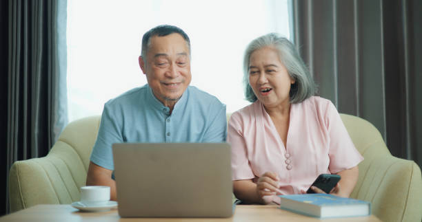istock Relaxed mature old 60s couple using a computer laptop to play social media 1806837050