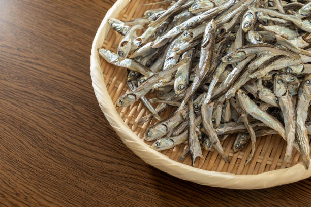 un montón de sardinas secas en un colador de bambú - pescado secado fotografías e imágenes de stock