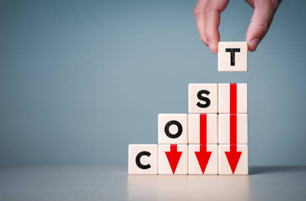 istock Cost reduction management concept. Lean optimize manufacturing. Decreasing company expense to maximize profits. Hand puts wooden cube with word cost and red down arrows. Company process improvement. 1806906481