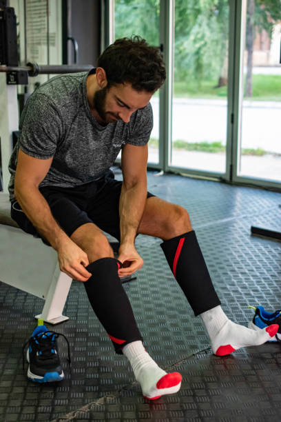 istock Athlete puts on protective equipment on the knee in the gym 1806921561
