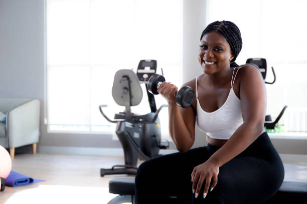 istock Young black woman training exercise or workout with lifting dumbbell for bodybuilder with strong in fitness gym, woman practicing weightlifting for strength of muscle and motivation, sport concept. 1806925039