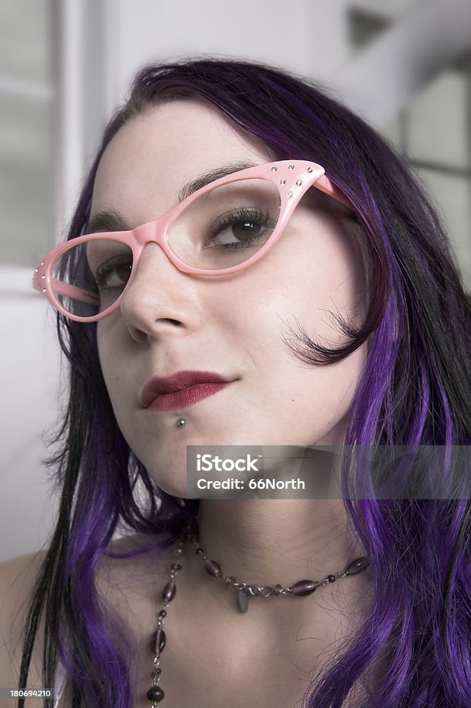 Purple and Pink A young beautiful woman with purple hair wears pink retro glasses. Dyed Hair Stock Photo