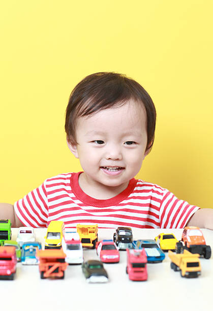 Cute Asian baby playing with car toys