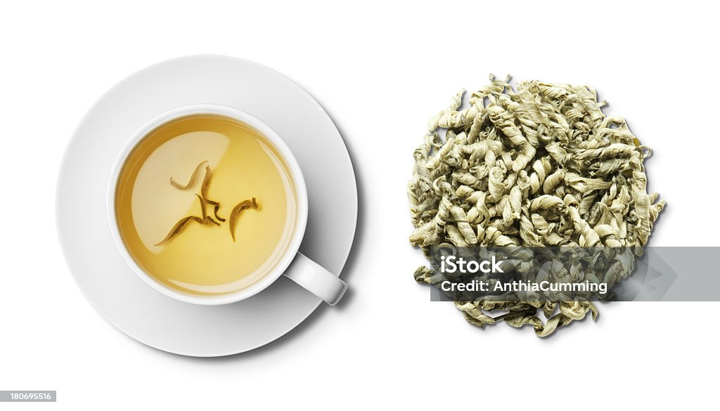 Cup of herbal snow dragon tea and tea leaves overhead Loose leaf Snow Dragon Tea and a cup and saucer of brewed Snow Dragon Tea shot from above and isolated on a white background with a clipping path Aerial View Stock Photo