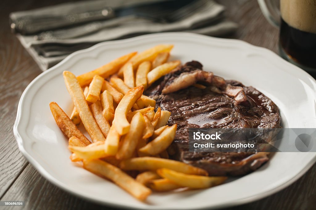 Bistecca di manzo con patatine fritte - Foto stock royalty-free di Alla griglia