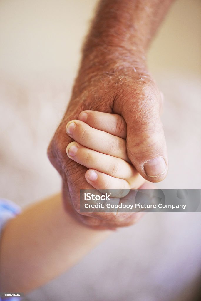 Young meets old Cropped view of a grandfather's hand holding his grandson's hand Adult Stock Photo