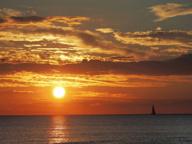 istock Ocean Sunset with a Sail Boat on the Horizon 1806971603