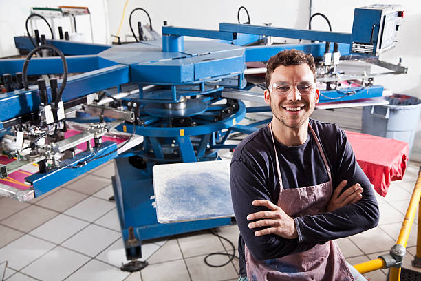 homem de negócios de impressão - young men printing plant printing press factory - fotografias e filmes do acervo