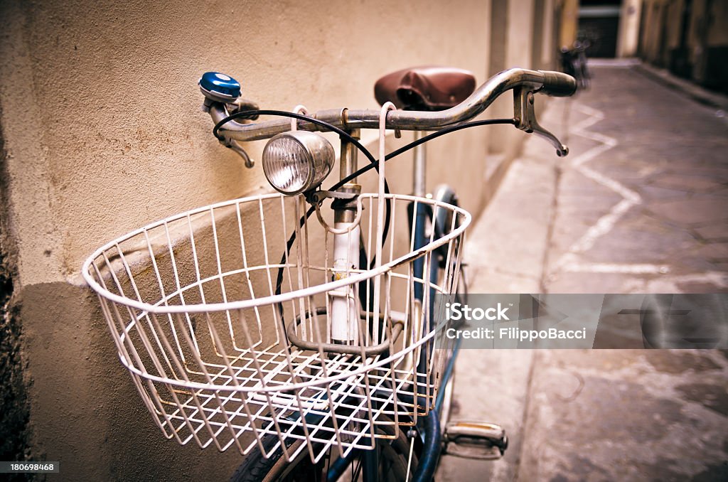 Bicycle against a wall in Florence, Italy Close up view of a bicycle leaning against a wall in a street in Florence, Italy. Alley Stock Photo