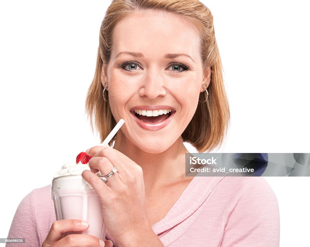 Woman Enjoying Milkshake Portrait of a beautiful young woman dressed in pink, holding a strawberry milkshake, about to take a sip with a huge smile on her face. Isolated on a pure white background. Milkshake Stock Photo