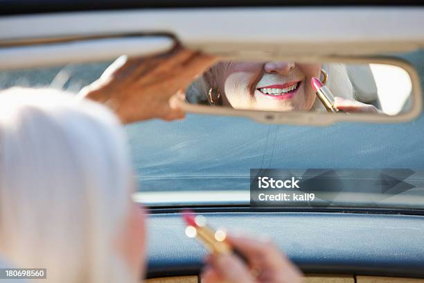 Senior Mujer Aplicar Lápiz Labial En Convertible Foto de stock y más banco de imágenes de Coche deportivo - Coche deportivo, Mujeres maduras, Conducir